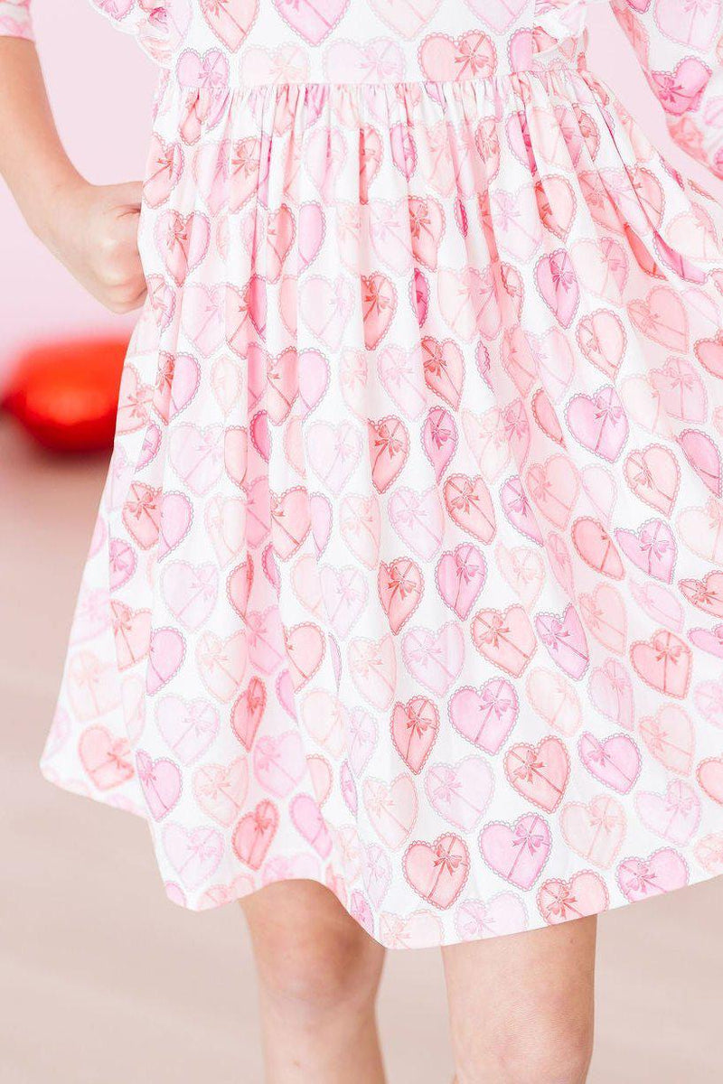 Close-up of the ruffled hem of the Melt My Heart 3/4 Sleeve Ruffle Twirl Dress, featuring a charming heart pattern, perfect for twirling adventures.