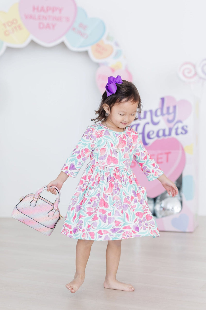 Watercolor Hearts 3/4 Sleeve Pocket Twirl Dress arranged flat showing the detailed stitching and vibrant pattern.