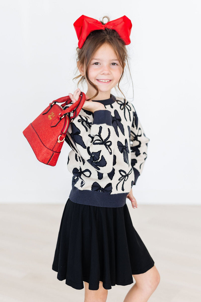 A model rocking the Perfectly Tied Sweater against a vibrant backdrop, perfectly capturing the essence of cozy fall fashion.
