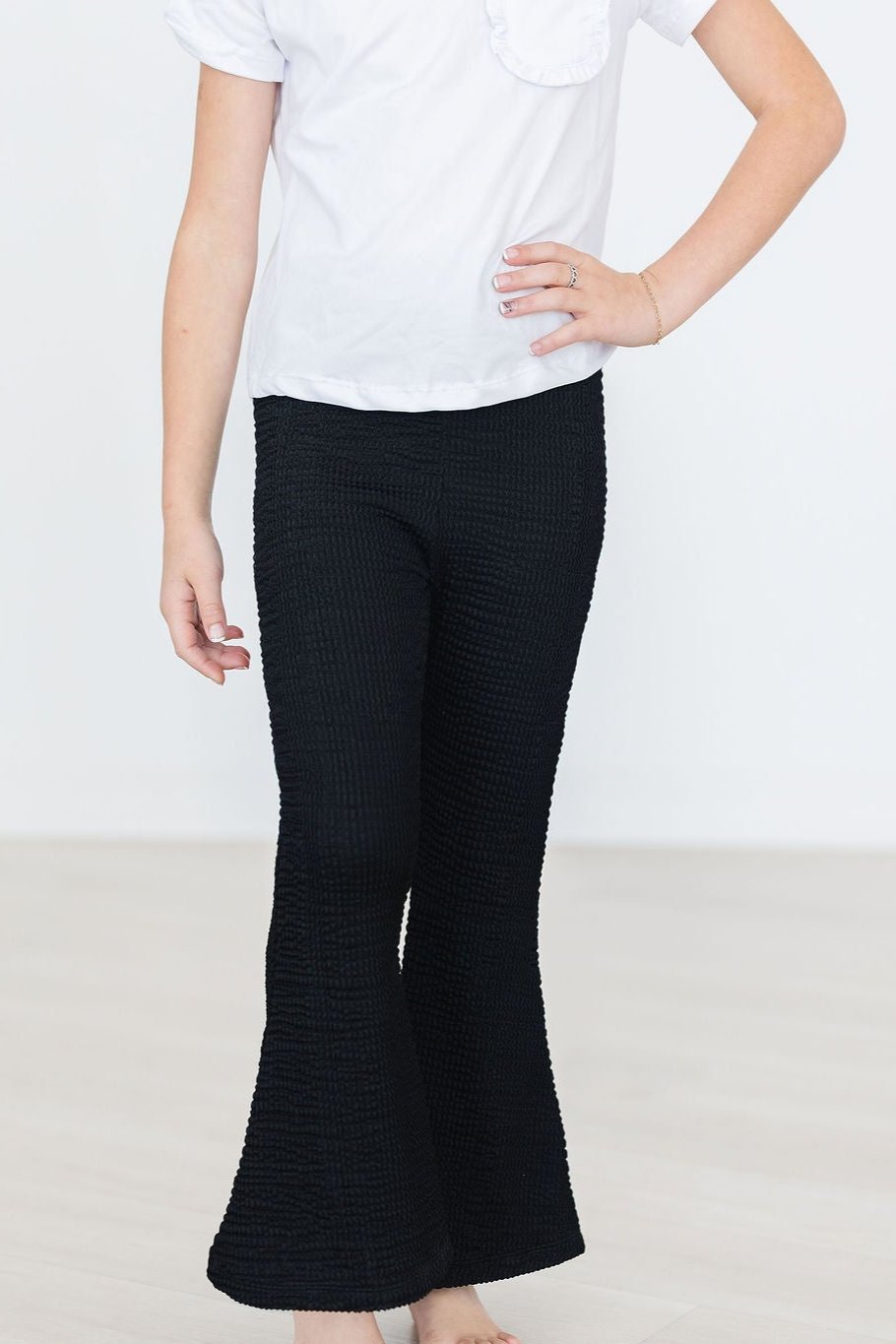 Black Scrunchy Bells displayed on a young girl in a casual white top, showcasing a fashionable and comfortable look, perfect for versatile outfits.