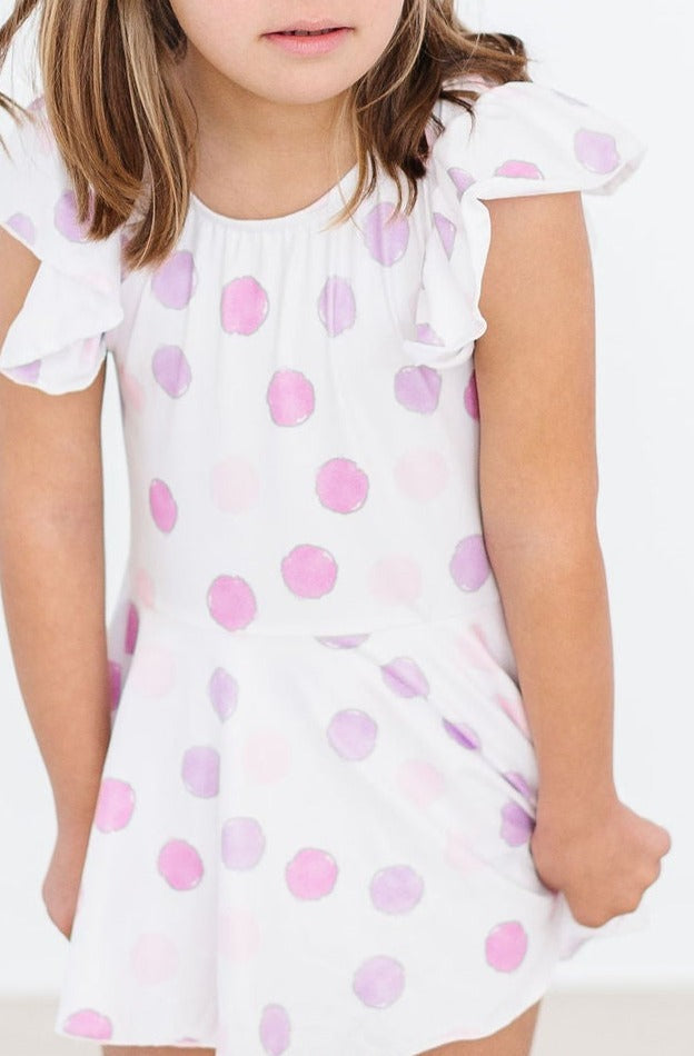 Close-up of a girl in the Pastel Polka Dot S/S Twirl Leotard by Mila & Rose®, featuring soft pastel polka dots and flutter sleeves, perfect for twirling.