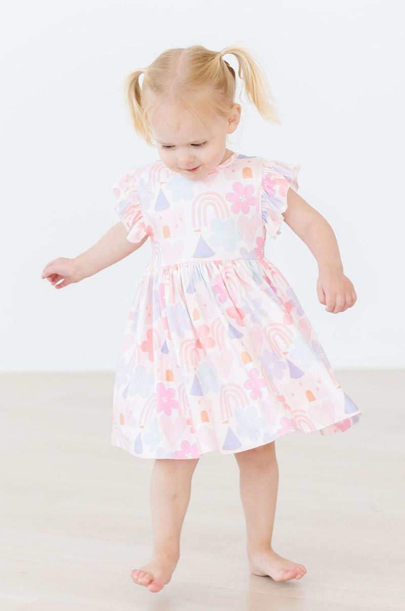 Close-up of Castles & Rainbows Flutter Sleeve Twirl Dress for Girls featuring vibrant colors and a scoop back design by Mila & Rose, perfect for twirling.