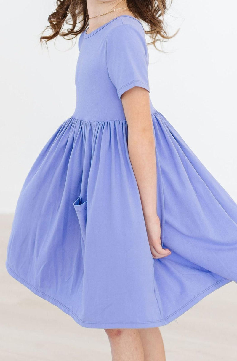 Side view of a child in the Periwinkle S/S Pocket Twirl Dress, emphasizing the playful skirt and magical twirl-ability.