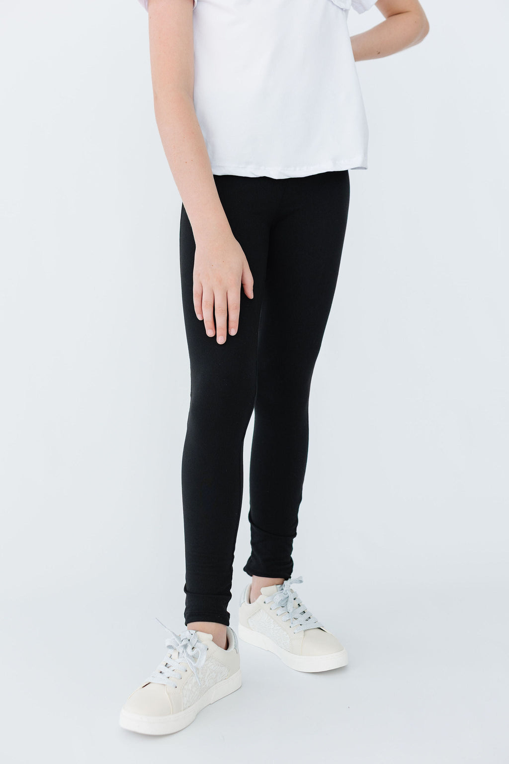 Comfy-Fit Black Leggings for Girls worn by a child in a simple white t-shirt, showcasing a snug fit and stylish look with sneakers.