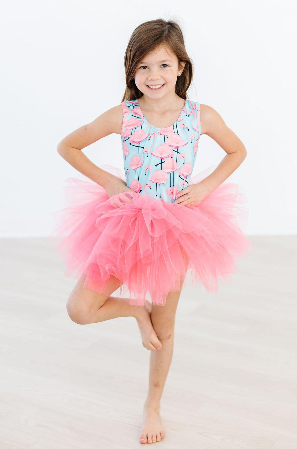 Young dancer wearing the Pretty in Pink Flamingos Tank Tutu Leotard by Mila & Rose, showcasing a vibrant flamingo print with a fluffy pink tutu, perfect for dance classes and play.