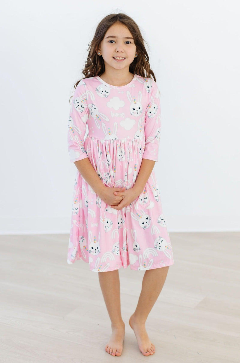Little girl enjoying a twirl in the Bunny Love 3/4 Sleeve Pocket Twirl Dress for Girls, showcasing its full skirt and sunny vibes.