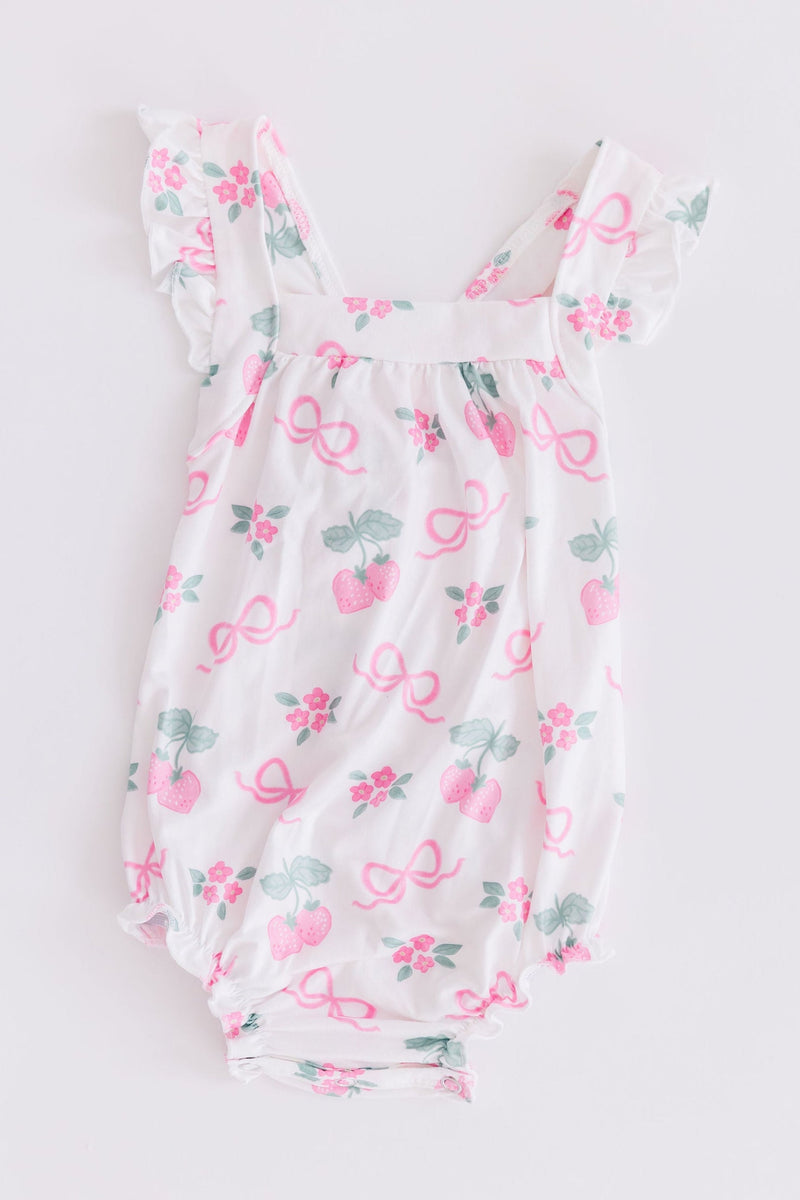 Flat lay of the Berries & Bows Ruffle Cross Back Romper, emphasizing durable fabric and vibrant colors for long-lasting wear.