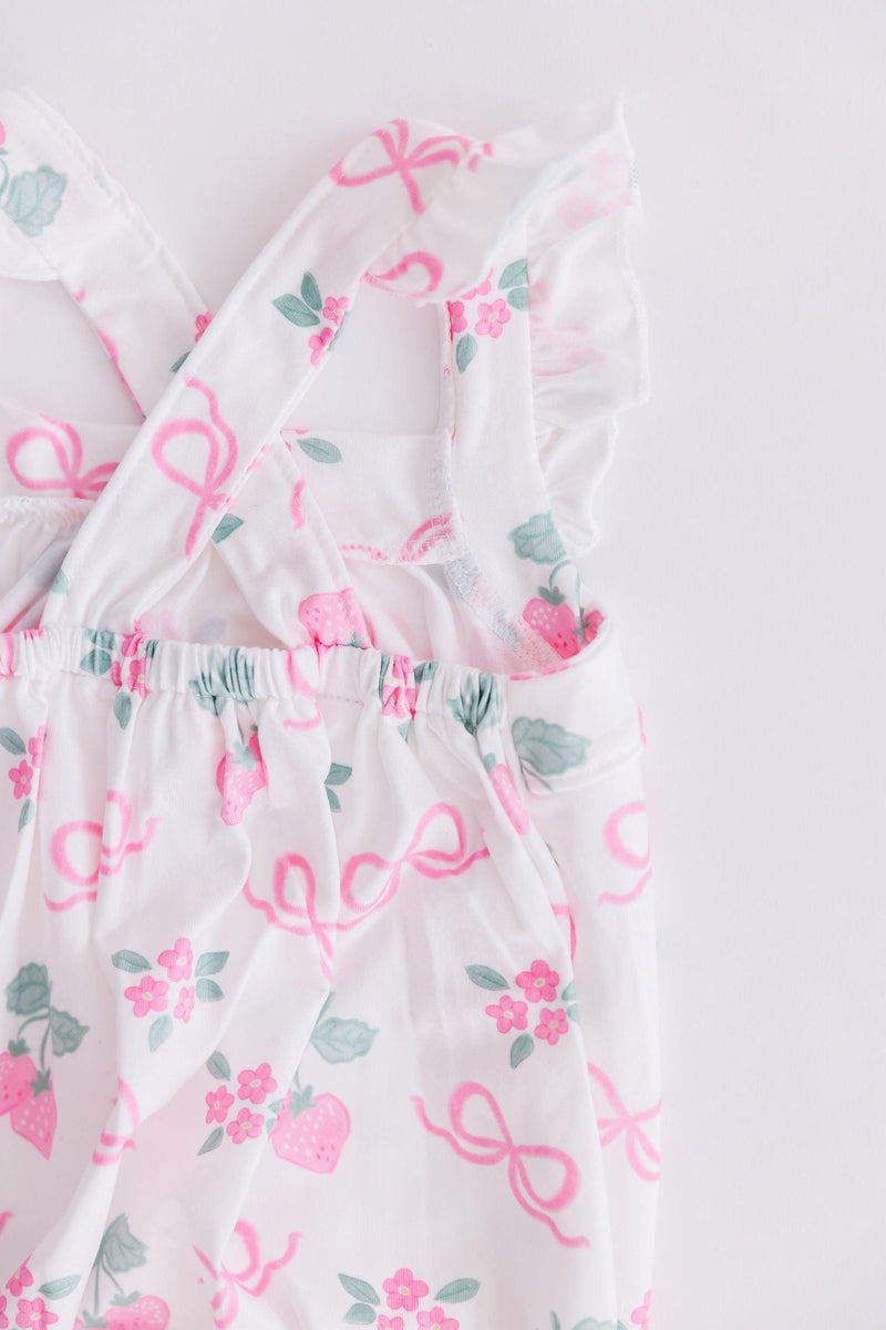 Close-up of the Berries & Bows Ruffle Cross Back Romper showcasing its unique ruffle shoulder design and practical snaps, ideal for easy dressing and comfort.
