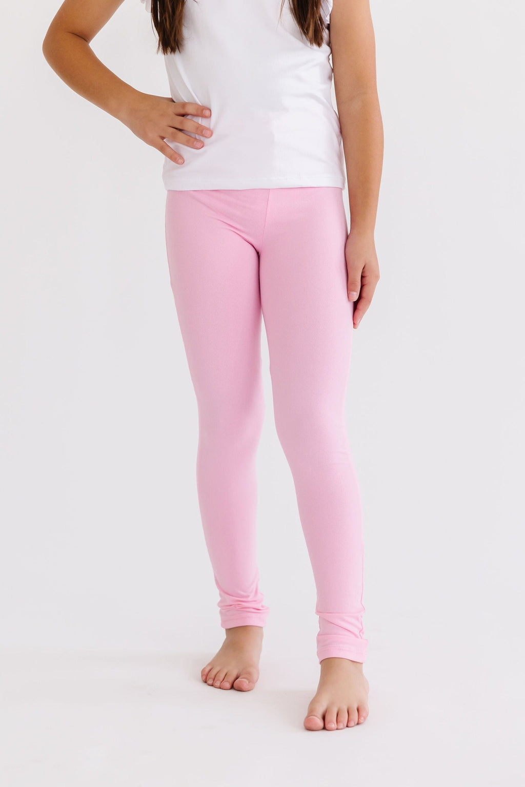 Girl wearing Bubblegum Pink Leggings with a white top, showcasing the vibrant color and slim fit design.