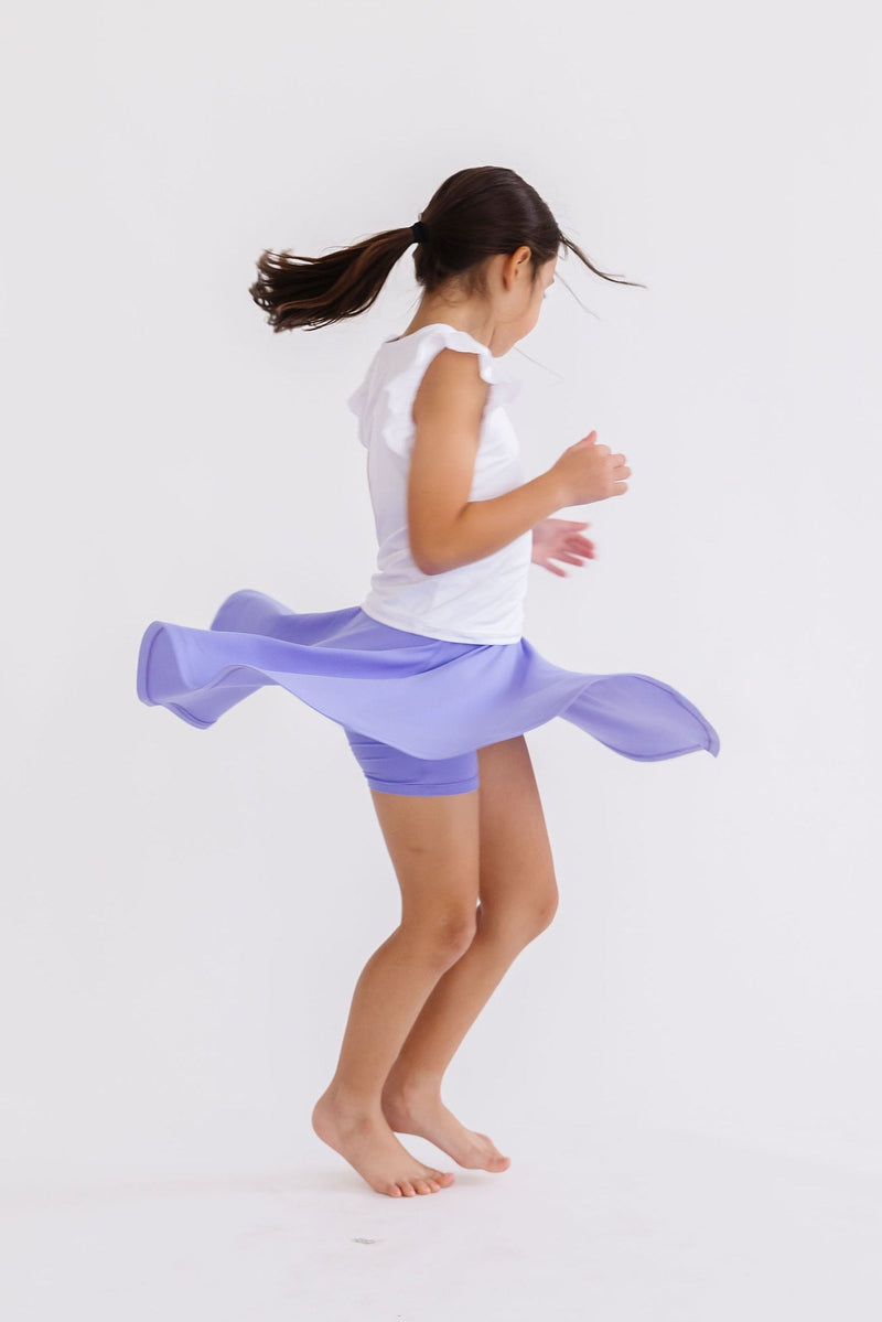 A joyful girl dancing in the Periwinkle Twirl Skort from Mila & Rose®, capturing the essence of fun and freedom in its lightweight, twirl-worthy design.