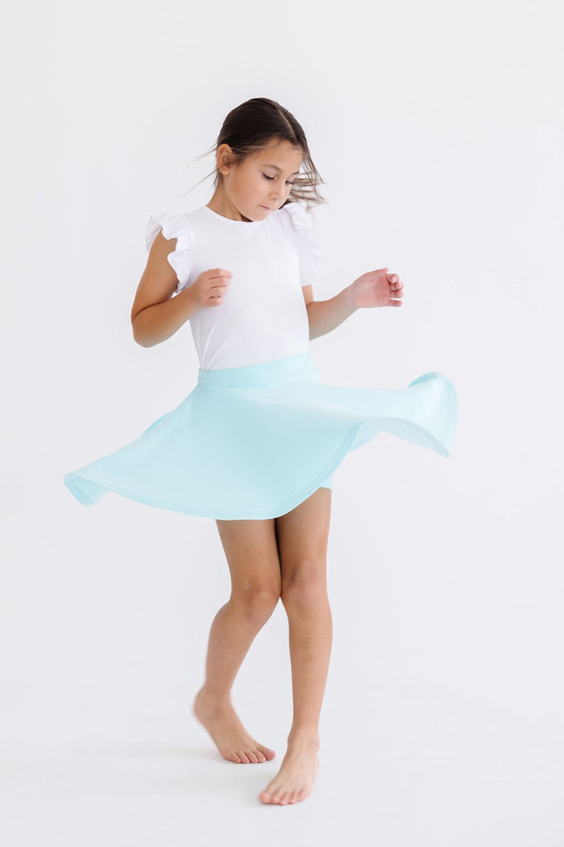 A young girl twirls in the Aqua Twirl Skort by Mila & Rose®, capturing the fun and movement that the skort allows.