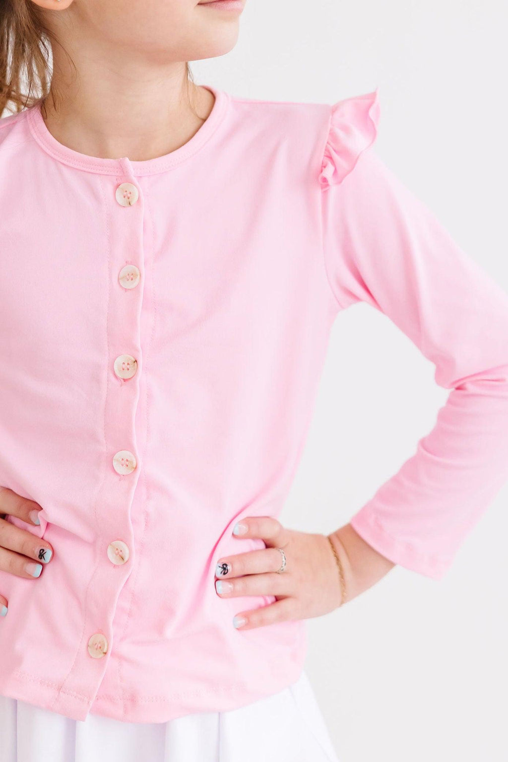 Bubblegum Pink Ruffle Cardigan for Girls displayed on a stylish mannequin, showcasing its playful ruffles and vibrant color for fashionable little adventurers.