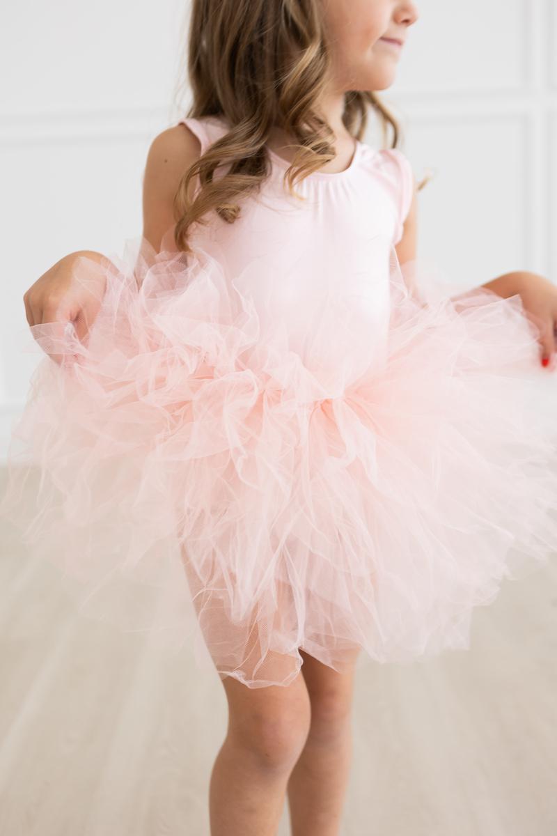 Young girl joyfully showcasing the 'Elana' Ballet Pink Tank Tutu Leotard, featuring a fluffy tutu, perfect for dance class or playful moments.