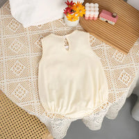 Cream 3D baby romper for infants with sleeveless design and gathered waist detail