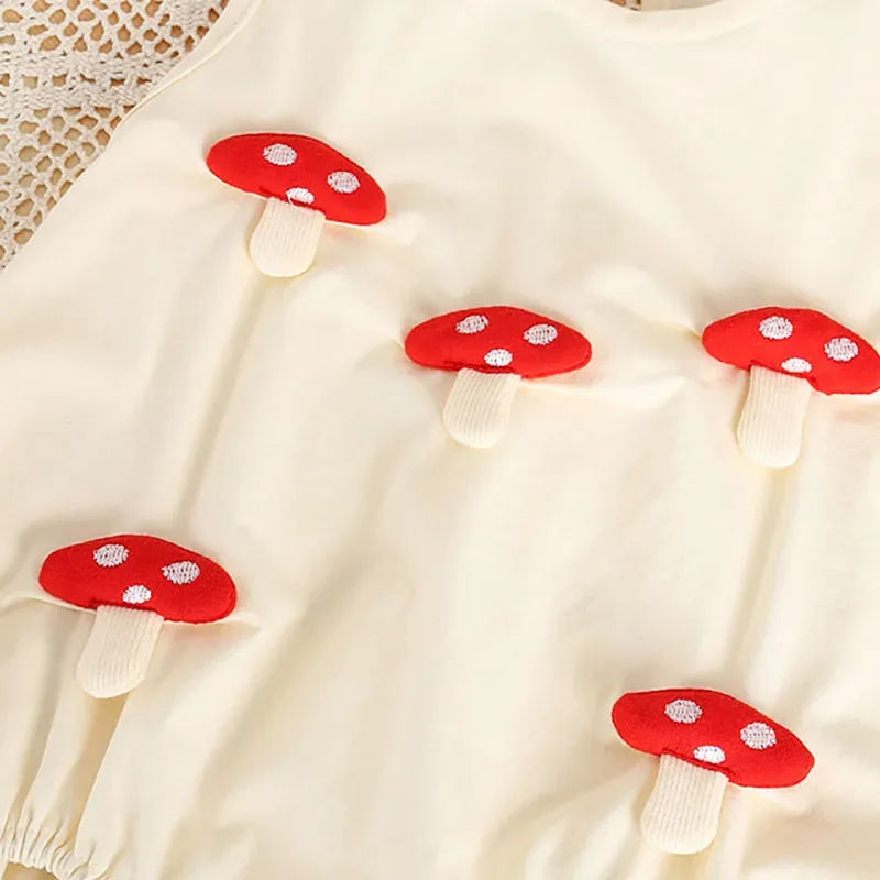 Cream 3D baby romper for infants with red mushroom applique details on soft fabric