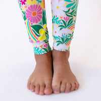 Colorful Rainbow Daisy Babe pajama pants with a floral print.