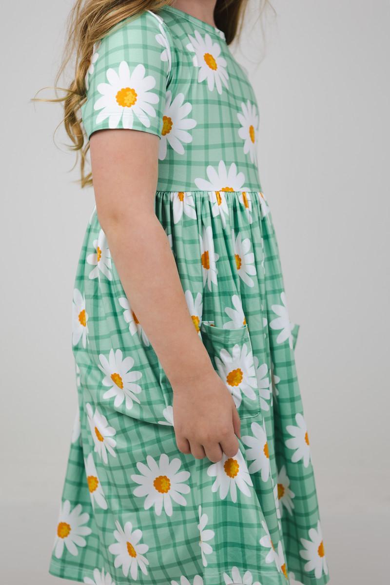 Side view of the Off the Grid S/S Pocket Twirl Dress showcasing its playful daisy design and comfortable fit, ideal for everyday adventures.