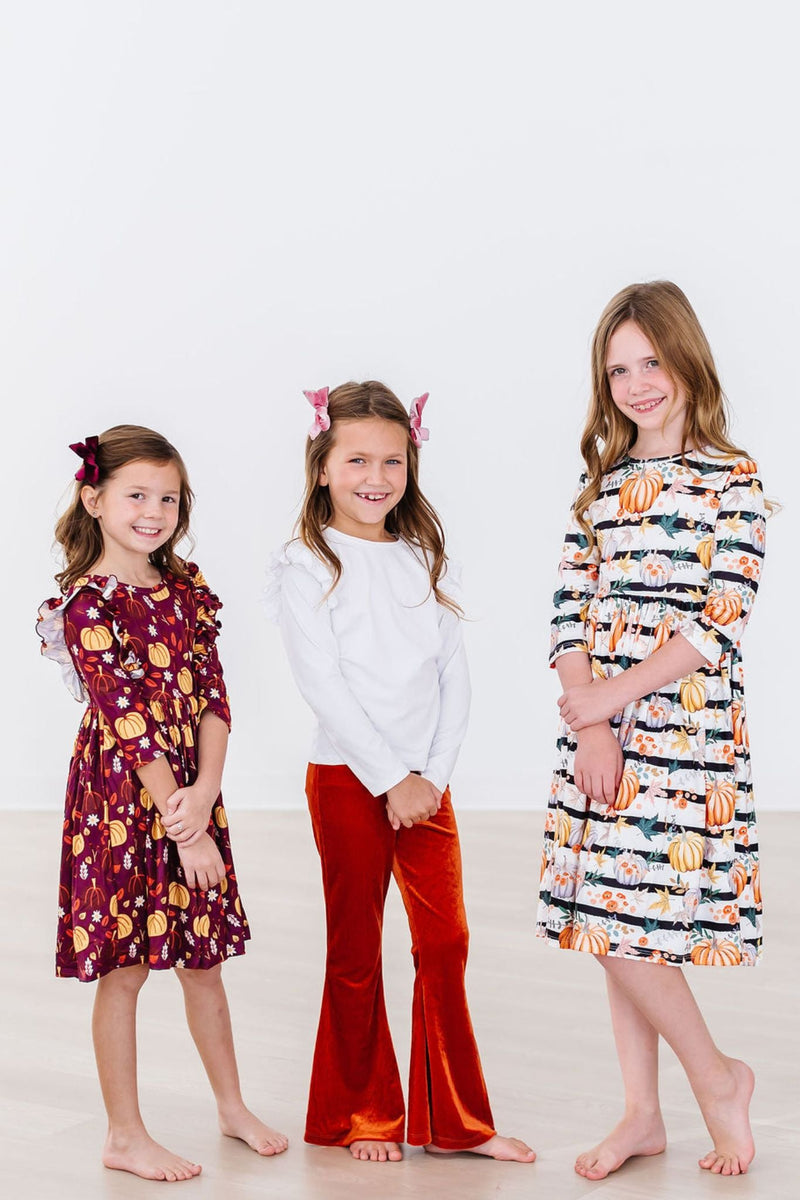 Unique features of the Pumpkins & Peonies 3/4 Sleeve Pocket Twirl Dress including pockets and a playful skirt that encourages fun movements.
