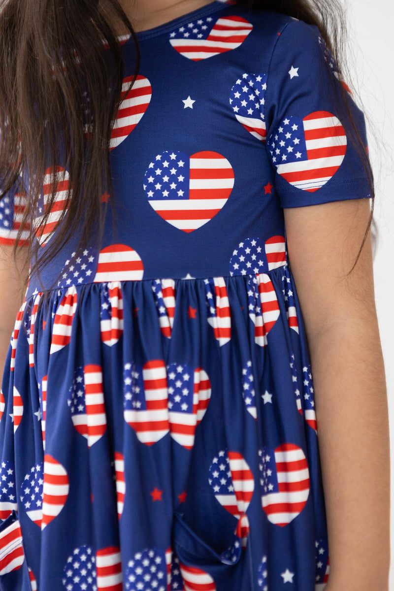 Detailed view of the 'I Heart the USA' Short Sleeve Pocket Twirl Dress for Girls, featuring a ballet neckline and festive heart designs with American flags, ideal for twirling.