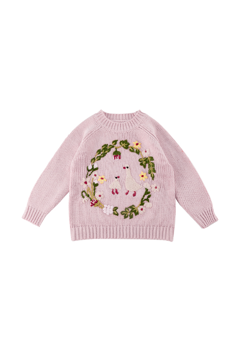A light pink knit sweater for toddlers, featuring a large central graphic of a white goose surrounded by a green floral wreath with small yellow and red flowers.