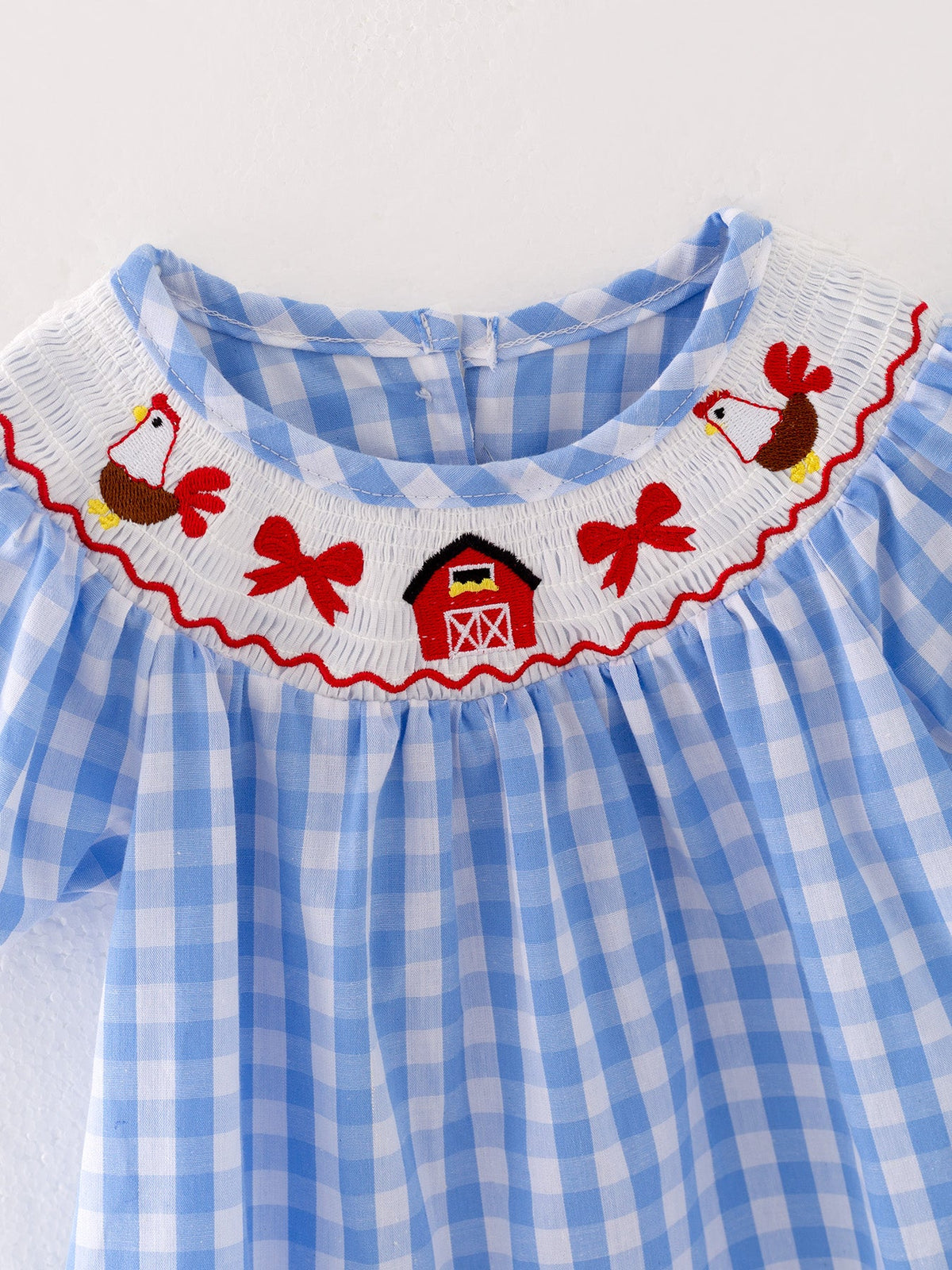 Young girl modeling the embroidered smocking dress, showcasing comfort and style with charming embroidery details.