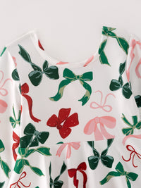 White girls dress featuring a festive print of green, red, and pink bows on the bodice and round neckline for holiday wear.