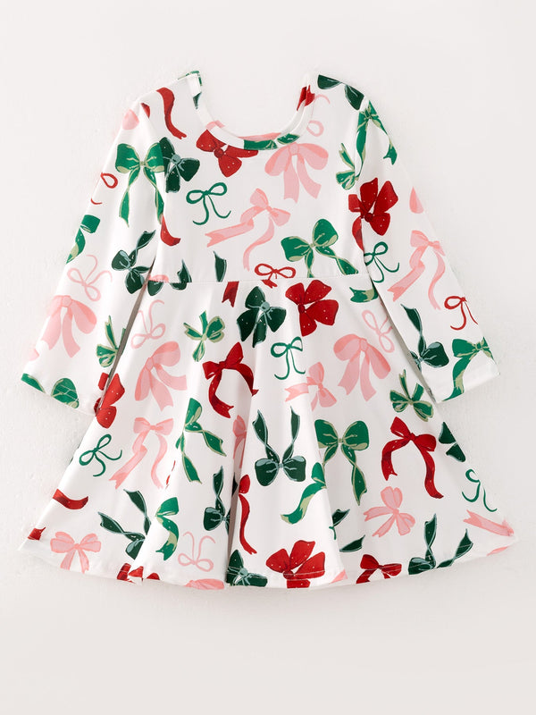 Festive white girls dress featuring red, green, and pink bow prints. Long-sleeve holiday dress perfect for Christmas events.