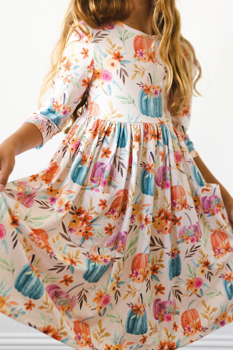 Harvest Blooms 3/4 Sleeve Pocket Twirl Dress featuring a playful floral and pumpkin print, perfect for twirling adventures and stylish fun!