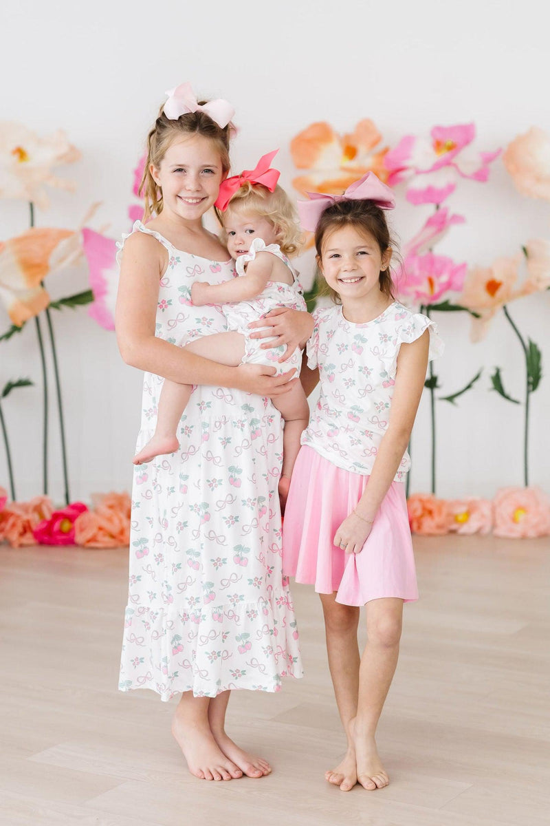 Cute little girl wearing the Berries & Bows S/S Ruffle Tee, perfect for playdates with its girlish charm and comfortable design.