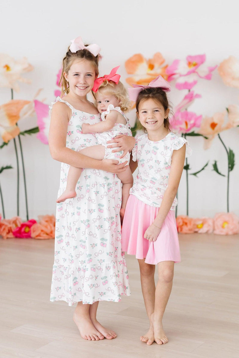 Toddler wearing the Berries & Bows Ruffle Cross Back Romper, demonstrating its playful fit and charming summer style.