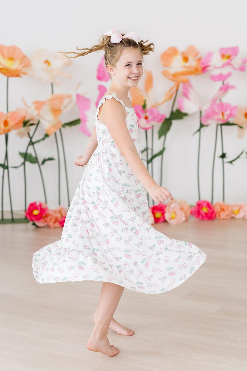 Child wearing the Berries & Bows Ruffle Maxi Dress at a summer playdate, showcasing its comfort and charm.