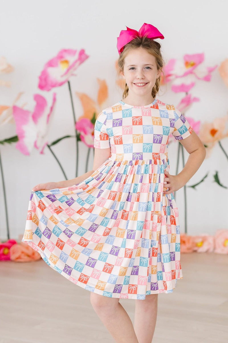 Close-up of the scoop back design of the Rainbow Ribbons S/S Pocket Twirl Dress, highlighting its stylish and functional features for active kids.