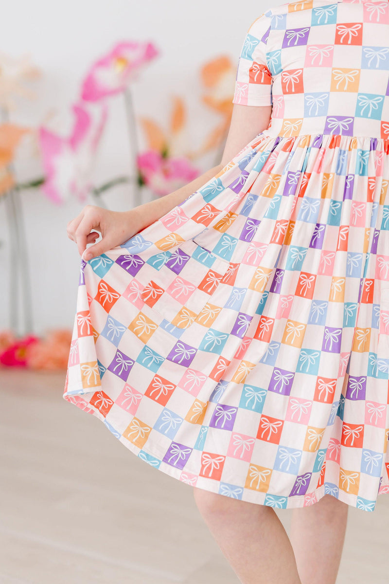 Rainbow Ribbons S/S Pocket Twirl Dress showcasing vibrant colors and playful patterns, perfect for little ones who love to twirl and dance.