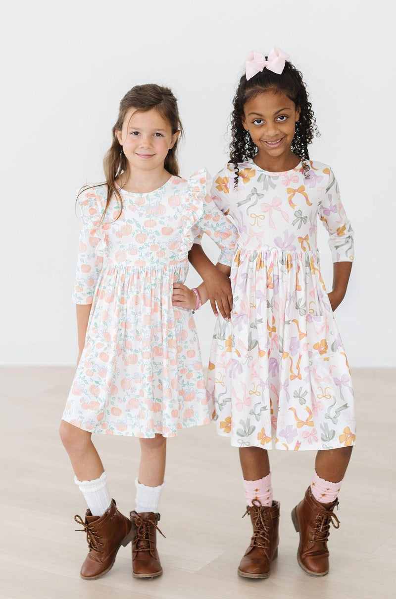 Back view of the Pretty Pumpkins Ruffle Twirl Dress with a scoop back design, allowing for easy dressing and a comfy fit for your little fashionista.