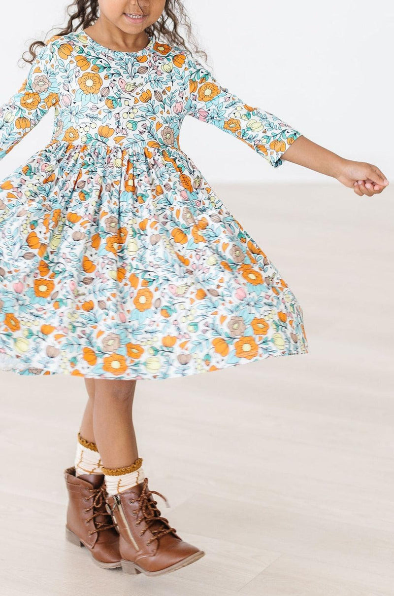 Girl spinning in her Vintage Vibes 3/4 Sleeve Twirl Dress for Girls, highlighting the dress's flowy style and cheerful floral pattern.