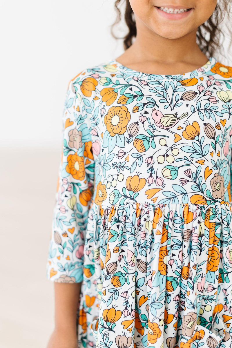Close-up of a girl wearing the Vintage Vibes 3/4 Sleeve Twirl Dress for Girls, showcasing the vibrant floral design and playful details.