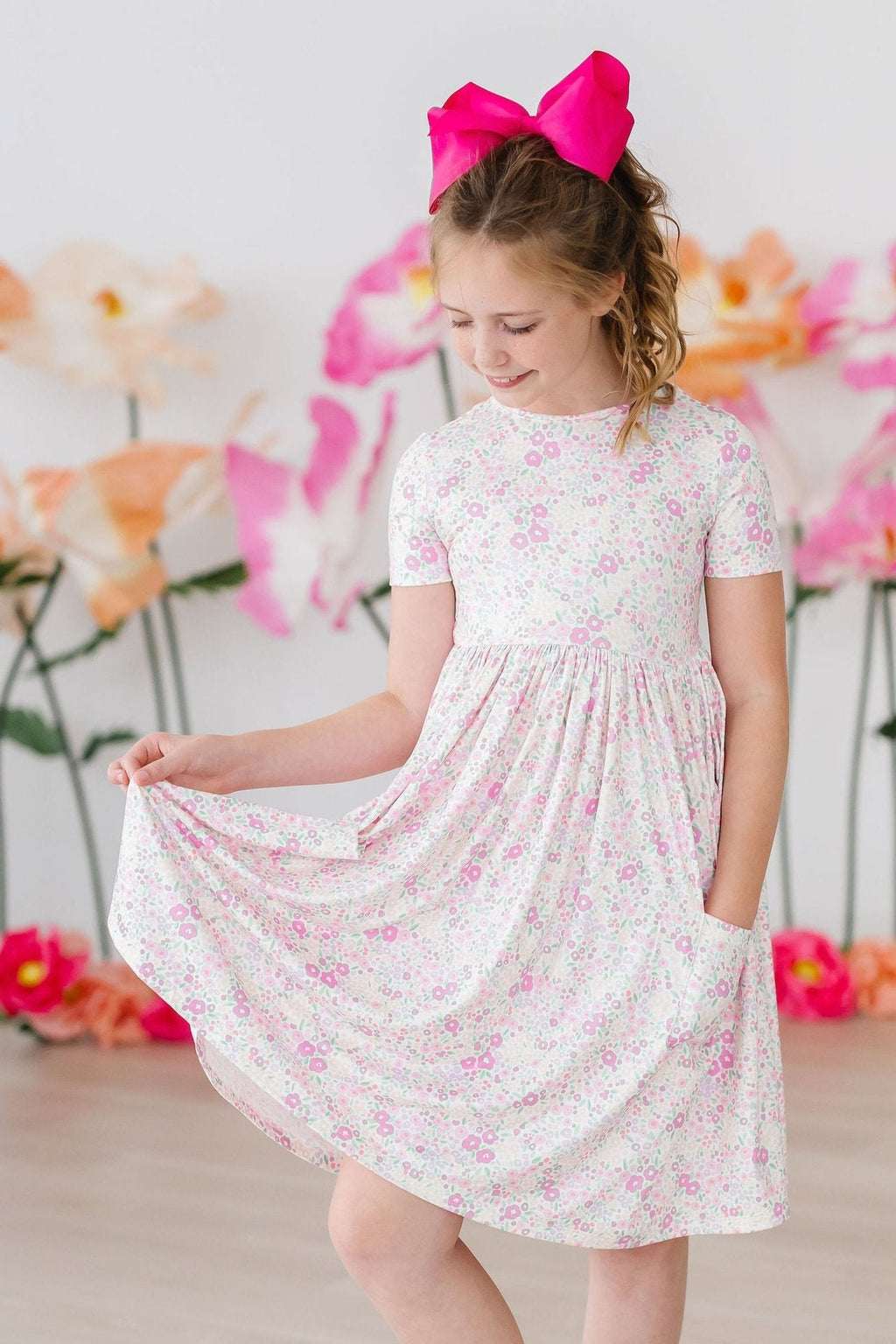 Blooming Beauty S/S Pocket Twirl Dress displayed on a hanger, showcasing its vibrant floral pattern and flouncy skirt.