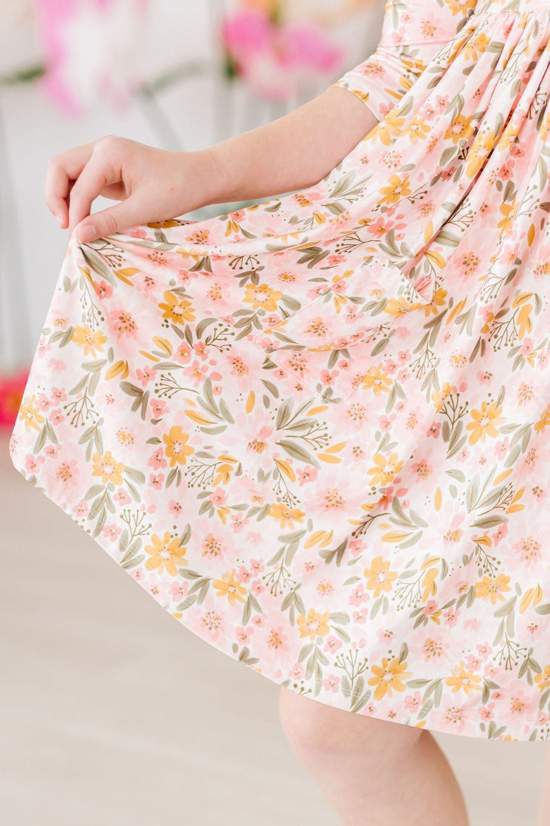 Delightful view of the twirly skirt of the Pretty Peachy 3/4 Sleeve Pocket Twirl Dress, highlighting its floral pattern and perfect twirl potential for fun-filled playdates.