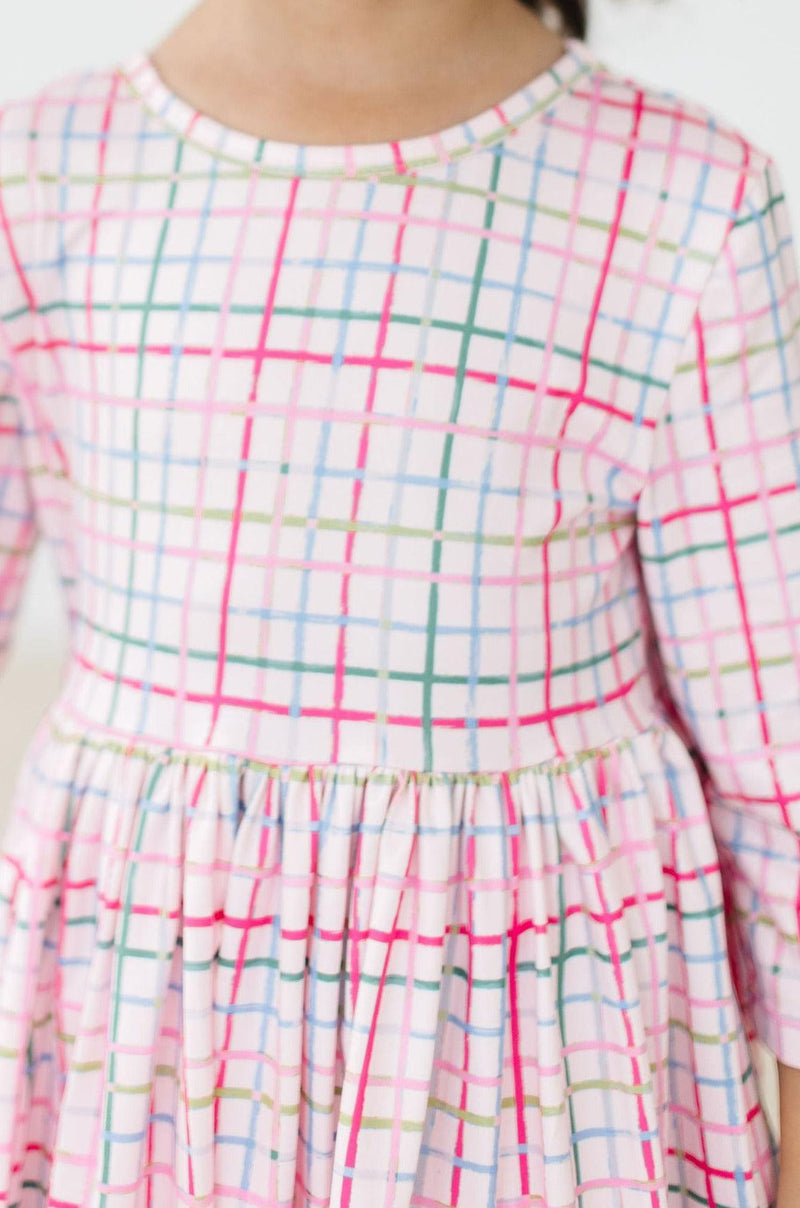 Close-up of the cozy fabric and playful pattern of the Pink Plaid 3/4 Sleeve Pocket Twirl Dress, ideal for twirling and fun.