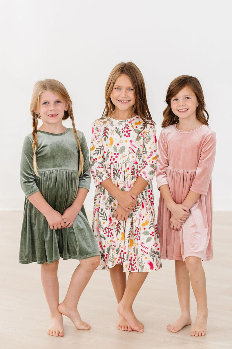 Three girls smiling in a photo, including one in a Vintage Pink Velvet Twirl Dress, emphasizing the dress's charm in a group setting.