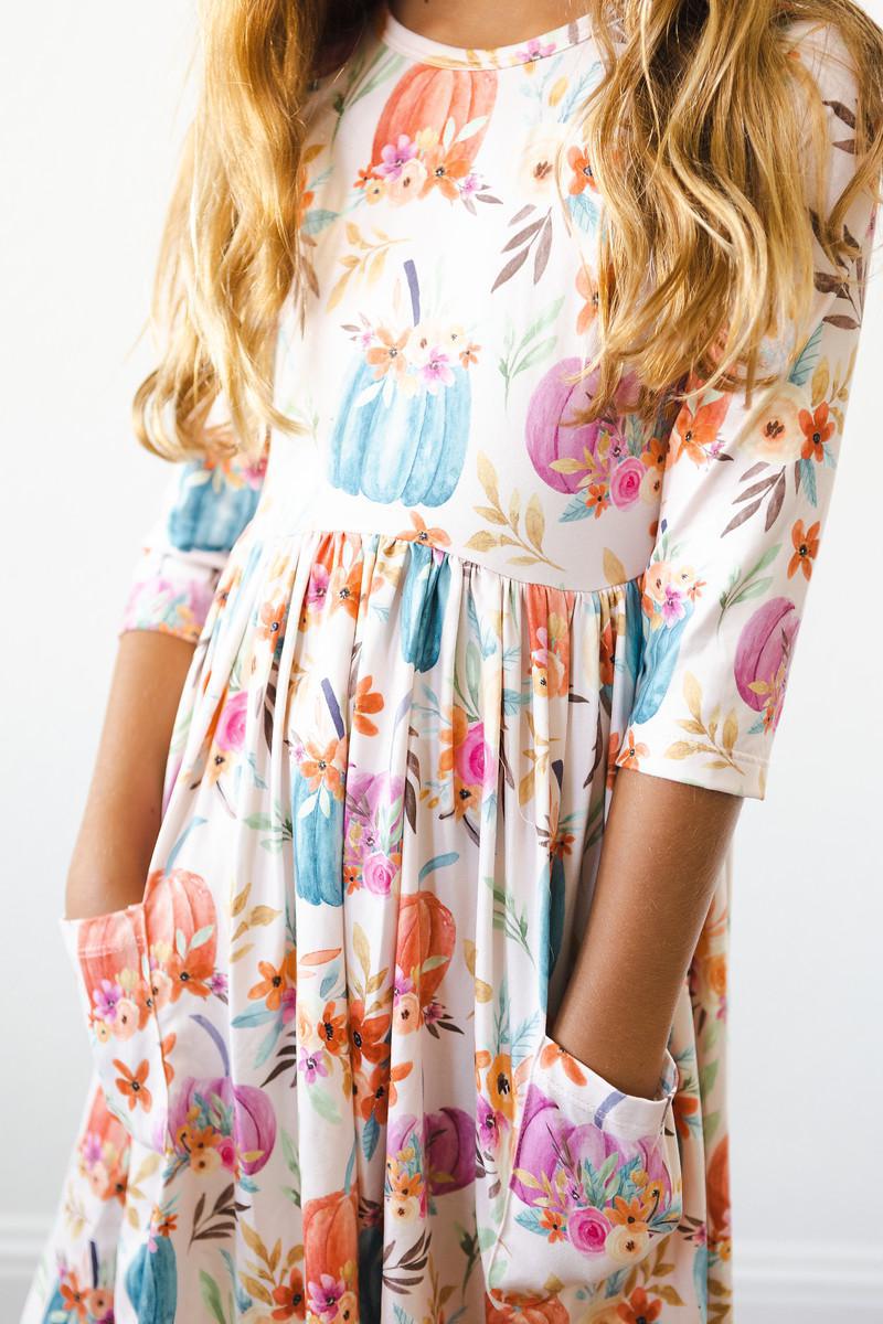 Close-up of the Harvest Blooms 3/4 Sleeve Pocket Twirl Dress, highlighting the playful pocket design and colorful floral print, ideal for fun outings.