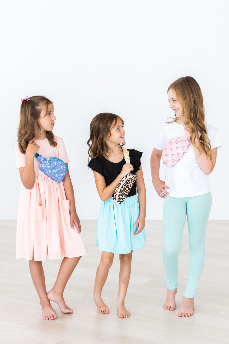 Three girls posing together, each wearing the Blue Moon Belt Bag in various playful colors, highlighting the fashionable look and versatility of this charming accessory.