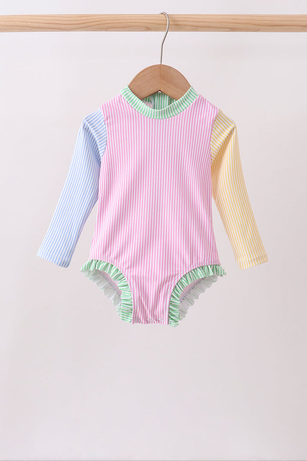 Pink striped rash guard swimsuit for kids with blue left sleeve, yellow right sleeve, green trim, UPF protection.