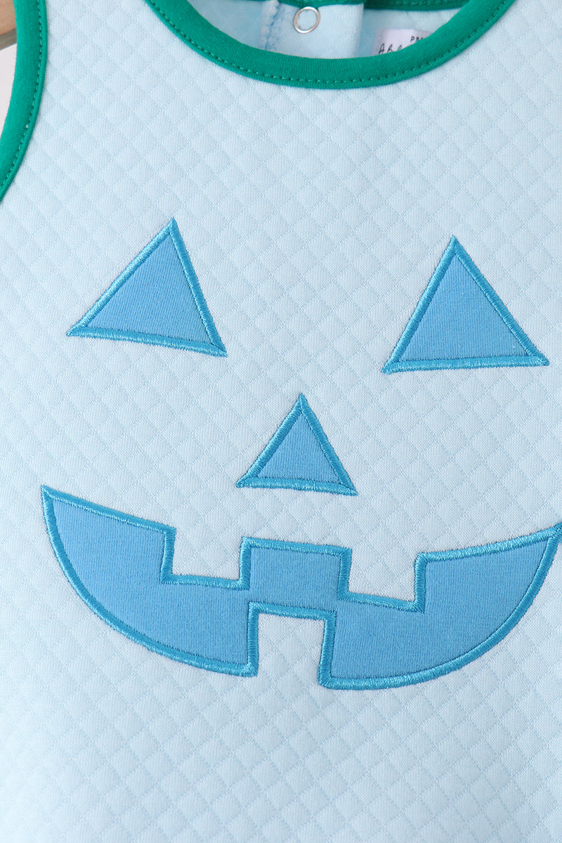 Blue jack-o-lantern appliqué on light blue bubble with diamond texture and green trim for festive Halloween wear.