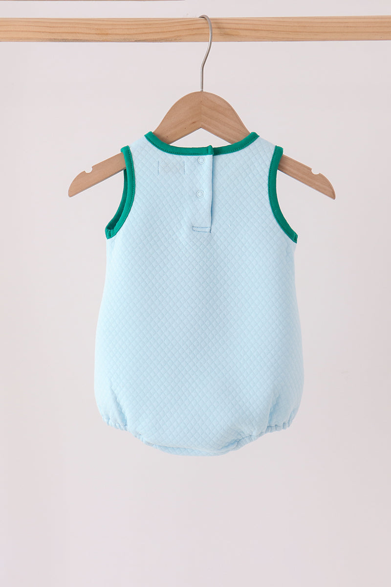 Back view of light blue quilted bubble with teal trim and snap buttons hanging on wooden hanger.