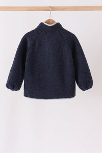 Back view of a navy fleece zippered jacket hanging on a wooden hanger, featuring a soft textured collar and cozy warmth for layering.