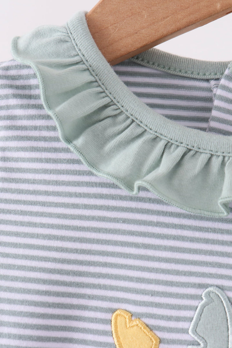 Close-up of a baby or toddler striped top on a wooden hanger, featuring a wide ruffled collar in a pale sage green and fine gray horizontal stripes.