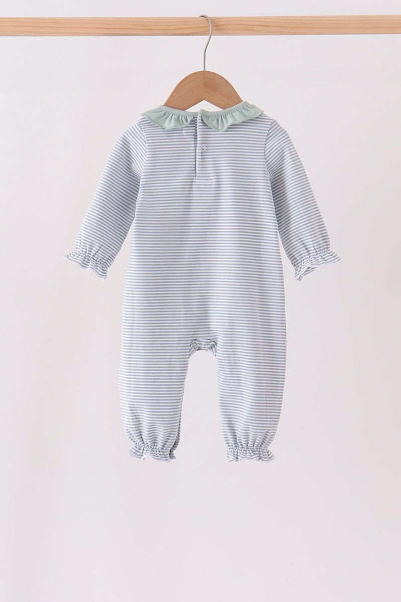 A baby hooded one-piece romper with thin blue and white horizontal stripes, featuring a pale green ruffled collar and ruffled cuffs, hanging on a wooden hanger against a plain light background.
