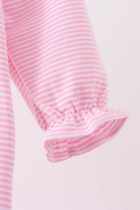 Close-up of a pink and white striped fabric garment sleeve with a gathered elastic cuff, shown against a plain light background.