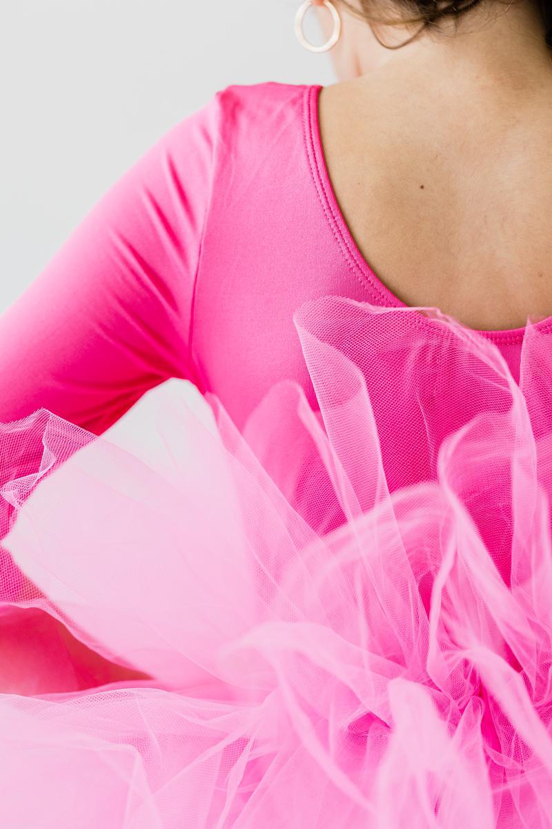 Close-up view of the back of a Hot Pink 3/4 Sleeve Fluffy Tutu Leotard for Girls, showcasing the scooped neck design and the fluffy tulle skirt. This charming tutu leotard for girls is perfect for dance and play.